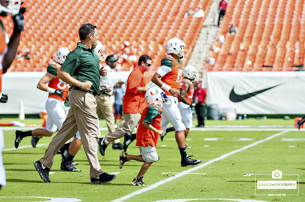 Carter Hucks, from Make-A-Wish foundation runs with the team at practice