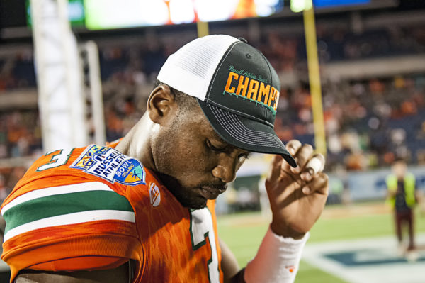 Stacy Coley putting on his Russell Athletic Bowl Champions hat