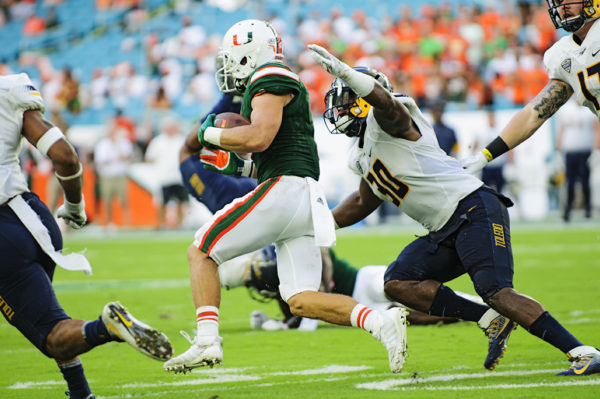 Hurricanes WR, Braxton Berrios, tries to run past defenders