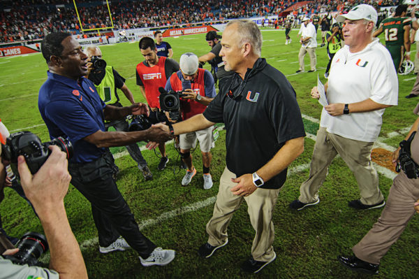 Coaches exchange handshakes after the game