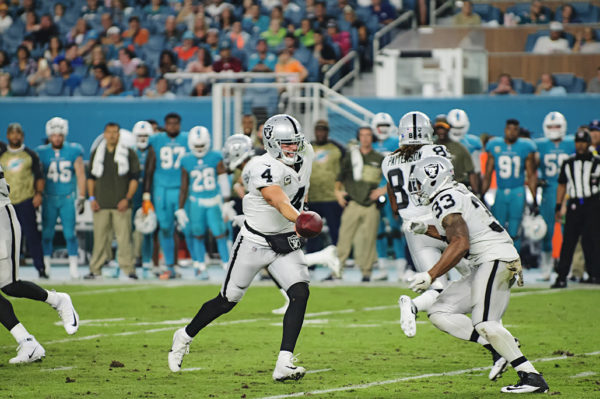 Derek Carr (4) hands off to DeAndre Washington (33)