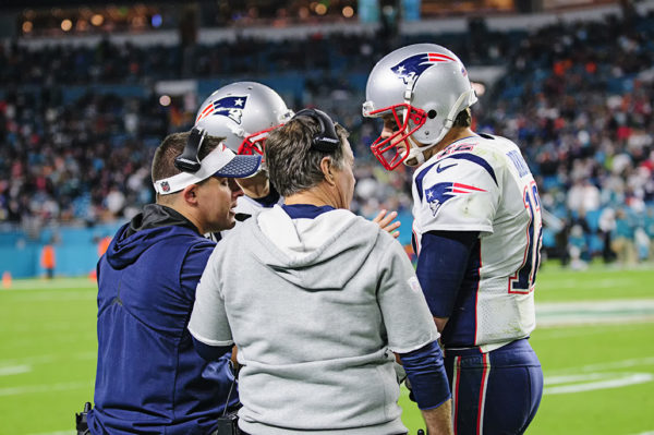 Tom Brady, Josh McDaniels and Bill Belichick talk during a timeout