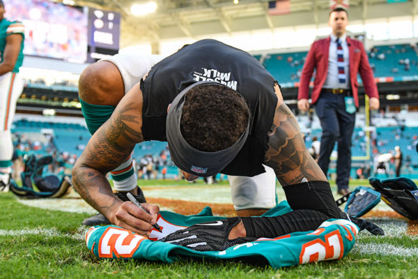 Miami Dolphins cornerback Torry McTyer (24) signs his jersey